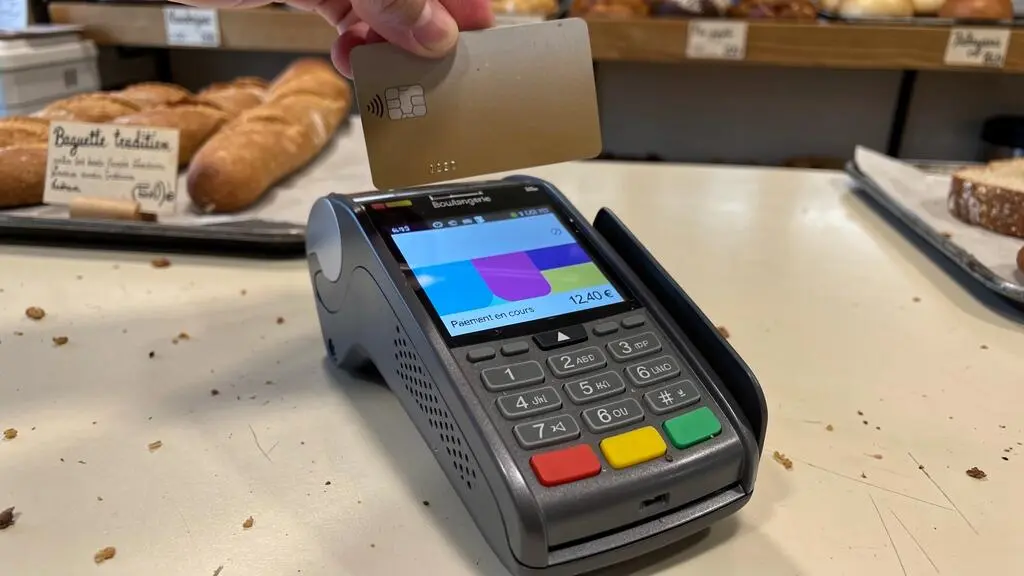 Client effectuant un paiement par carte bancaire sans contact sur un terminal dans une boulangerie
